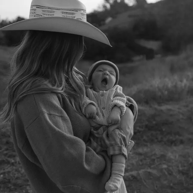 A parent holds a newborn during the early days at home.